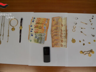 Ha mantenuto il sangue freddo durante tutta la telefonata, ha intuito immediatamente il raggiro e ha collaborato con i carabinieri fino al momento decisivo dell’arresto. Protagonista della vicenda una pensionata di 85 anni residente a Mappano, riuscita a far fallire un tentativo di truffa orchestrato con il classico schema del falso incidente e del presunto intervento sanitario urgente. La donna ha ricevuto una chiamata sul telefono di casa da un uomo che si è presentato come medico dell’ospedale Molinette. Il falso sanitario le ha raccontato che il figlio si trovava in gravi condizioni e che, per affrontare un delicato intervento chirurgico, sarebbe stato necessario reperire immediatamente una somma elevata di denaro. In alternativa, sarebbero bastati gioielli e oggetti preziosi custoditi nell’abitazione. L’anziana, però, ha compreso quasi subito che qualcosa non tornava. Non avendo figli maschi, ha intuito di trovarsi davanti a un tentativo di raggiro e ha contattato la figlia, che a sua volta ha avvisato i carabinieri della Centrale Operativa di Venaria. Il piano concordato con i militari A quel punto è scattata la strategia investigativa. L’operatore della centrale ha consigliato alla pensionata di continuare la conversazione senza interrompere il contatto con i truffatori. La donna ha quindi finto agitazione e smarrimento, lasciando credere di essere caduta nella trappola. Durante la chiamata, il sedicente medico ha passato il telefono a un complice che impersonava il figlio malato. Con voce sofferente, l’uomo ha spiegato che una donna sarebbe passata di lì a poco a ritirare l’oro necessario per coprire parte delle spese mediche. Nel frattempo i carabinieri della Sezione Operativa di Venaria e della Stazione di Leinì avevano già raggiunto l’abitazione dell’anziana, predisponendo un servizio discreto all’interno della casa. L’arresto in flagranza Pochi minuti dopo si è presentata una donna di 41 anni, cittadina polacca, che ha ritirato i monili preparati dall’anziana. Appena entrata in possesso degli oggetti preziosi, i militari sono intervenuti bloccandola e arrestandola in flagranza con l’accusa di tentata truffa aggravata. Nel corso della perquisizione personale, i carabinieri hanno trovato anche altri gioielli, un orologio del valore stimato di circa 15 mila euro e 350 euro in contanti. Gli investigatori sospettano che il materiale possa provenire da analoghi episodi avvenuti recentemente nel Torinese. Per questo motivo sono in corso ulteriori accertamenti. Un precedente già nel 2024 Per l’85enne non si tratta del primo episodio simile. Già nel febbraio del 2024 era riuscita a sventare un’altra truffa con modalità analoghe, consentendo in quell’occasione l’arresto di un giovane cittadino tedesco di 18 anni. Grazie alla prontezza dimostrata anche questa volta, la pensionata è riuscita a rientrare in possesso dei propri gioielli senza subire danni economici. La quarantunenne arrestata è stata invece trasferita nel carcere “Lorusso e Cutugno” di Torino, dove resta a disposizione della Procura di Ivrea che coordina le indagini.